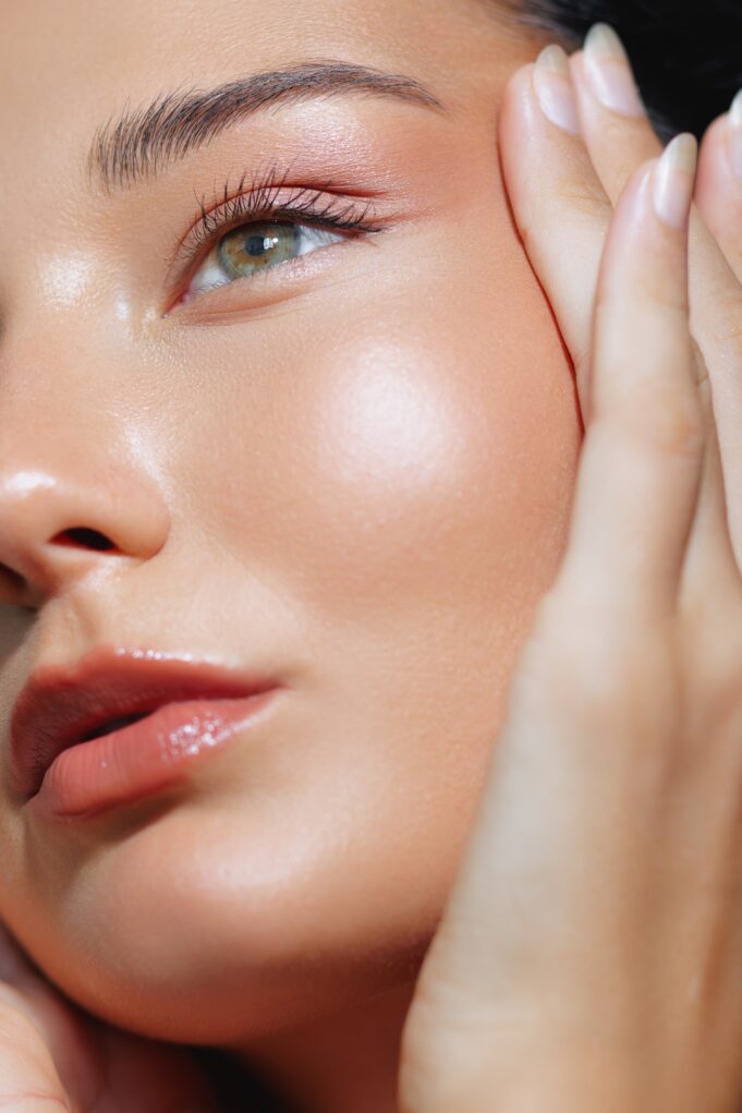 Close-up,Portrait,Of,A,Woman,With,Radiant,Skin,And,Hands The "Dissolving" Trend: Embracing Natural Aesthetics
